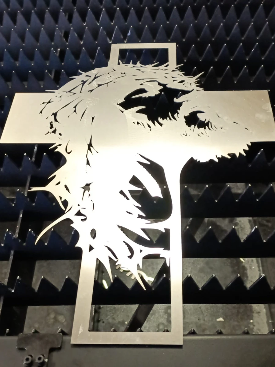 Metalowy krzyż z wizerunkiem twarzy Chrystusa wykonany w usłudze Cięcia laserowe na stole roboczym